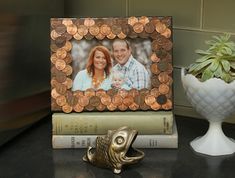 a photo frame made out of penny coins sitting on top of books