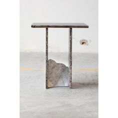 a table with a piece of rock in the middle of it on top of concrete