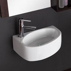 a white bathroom sink sitting on top of a counter next to a wall mounted mirror