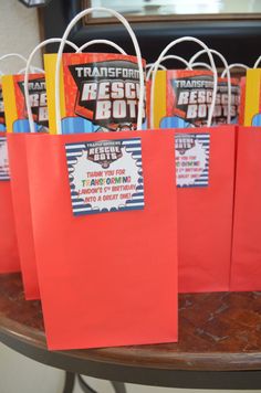 small red bags with tags on them sitting on a table