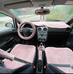 the interior of a car with pink carpet and plush steering wheel covers on it's dashboard