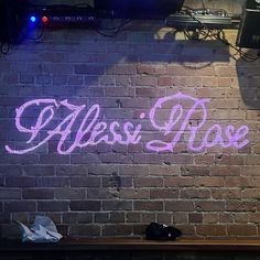 a brick wall with the word miss rose painted on it in purple and white letters