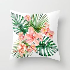 a white pillow with pink flowers and palm leaves