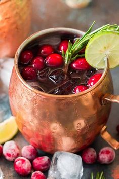 cranberry moscow mule in a copper mug with ice and garnishes