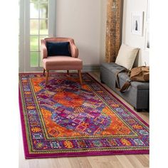 an orange and pink rug in a living room with a chair on the far side