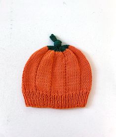 an orange knitted pumpkin hat on a white surface