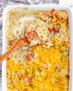 a casserole dish with meat and vegetables in it, topped with a wooden spoon