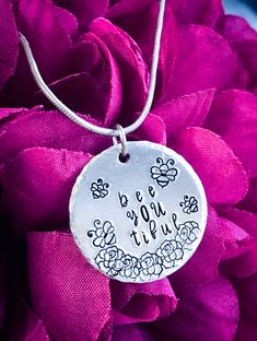 Here we have a beautiful 'Bee You Tiful' Necklace / Pendant.  ☆ Design☆ Each Necklace is made from a 25mm Round, 1.5mm thick / 14gauge Aluminium blank with textured edges hand stamped by myself with 5.5mm & 3.5mm Bee Symbols, 5.5mm Rose Symbols and 3mm 'bee YOU tiful. It is finished with a Stainless Steel jump ring and a 18inch Stainless Steel snake chain with lobster claw clasp.  ☆Upgrades & Add Ons☆ Why not upgrade the Snake chain to a Stainless Steel Rolo Chain - Click below https://www.etsy. Letter Symbols, Hand Stamped Necklace, Bee Necklace, Rose Necklace, Rolo Chain, Initial Charm, Hand Stamped, Favorite Jewelry, Initials