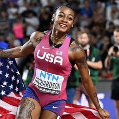 a woman running with an american flag in the background