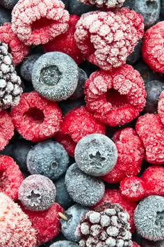 frozen berries and raspberries are shown in this close up photo, with blueberries on the side