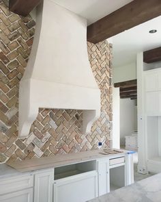 a kitchen with white cabinets and a brick oven