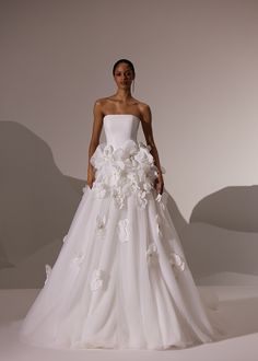 a woman in a white wedding dress with flowers on it