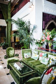 a living room filled with lots of green furniture and plants on top of it's walls