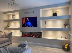 a living room filled with furniture and a flat screen tv mounted to the side of a wall