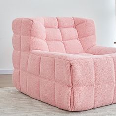 a pink couch sitting on top of a wooden floor