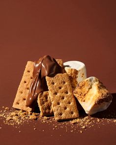 a pile of crackers and marshmallows on a brown background with chocolate