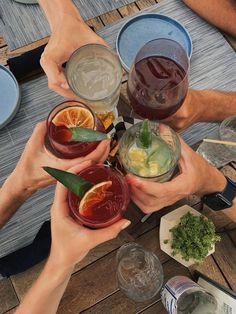 several people are holding their glasses with drinks in them