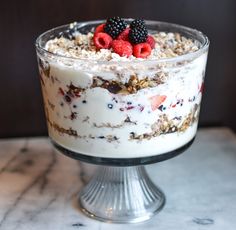 a dessert with berries and granola in a glass dish