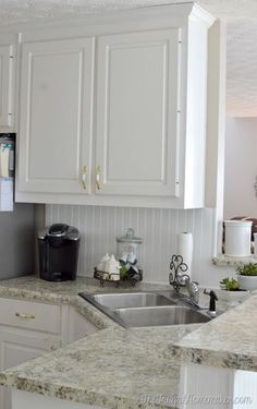 a kitchen with white cabinets and granite counter tops