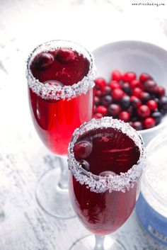 two glasses filled with red wine and berries