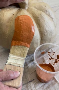 someone is painting a pumpkin with brown paint