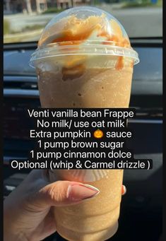 a person holding up a drink in front of a car window with the words, venti vanilla bean frappe no milk use at milk and extra pumpkin sauce