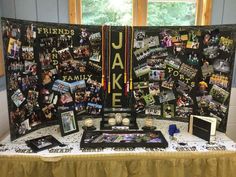 a table topped with pictures and photos next to a large sign that says jake