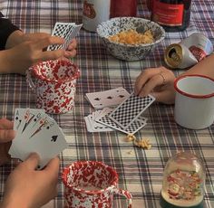 people sitting at a table playing cards and cups