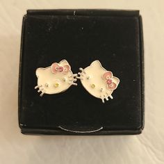 two hello kitty earrings are in a black box