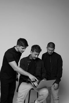 three men are looking at something on a piece of paper