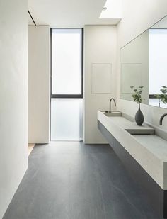 a modern bathroom with two sinks and large mirrors