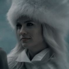 a woman with long blonde hair wearing a white fur hat