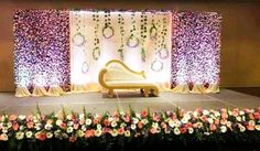 a stage set up with flowers and greenery for a wedding or special function event