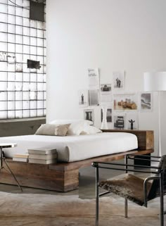 a bed sitting in the middle of a bedroom next to a chair and table with two lamps on it