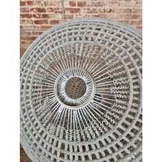 a circular metal object on top of a brick wall