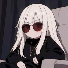 a woman with white hair and sunglasses sitting in a chair