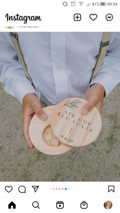 someone is holding two wooden coasters in their hands