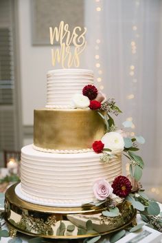 a white and gold wedding cake sitting on top of a table