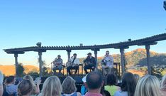 a group of people sitting on top of a stage