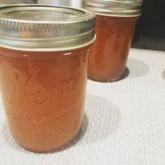 three jars filled with liquid sitting on top of a table