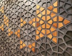 an intricately designed wall with gold and silver geometric designs on it's sides