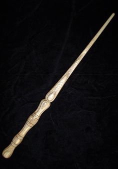 an old wooden stick is sitting on a black cloth background, with the handle missing