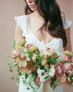 a woman holding a bouquet of flowers in her hands