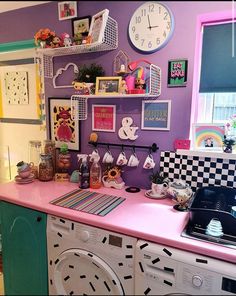 a pink counter top in a kitchen next to a washer and dryer with pictures on the wall