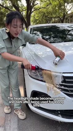 a woman washing the hood of a white car