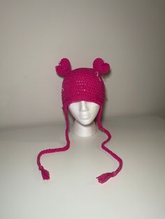 a pink knitted hat with ears on top