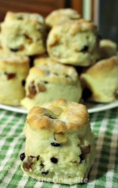 a white plate topped with muffins on top of a green and white checkered table cloth