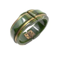 This stylish example of Bakelite jewellery dates from the 1930s.  Condition Report: Excellent The Details... This hinged cuff is constructed from marbled green Bakelite. It is detailed with 4 gilded metal bands. The internal diameter of this cuff is 6cm, making the internal circumference 18.8cm. A Short History... This cuff is made from the thermoset plastic Bakelite used popularly in jewellery manufacture from the 1910s through to the 1940s. It has been proven to be Bakelite through testing. It is evocative of the wartime era, when manufacture of luxury items, such as jewellery, could only really be achieved through the use of cheap, man-made materials. Wear it With... Stack this bracelet with others of similar shades to add interest to a cream silk shirt and jeans.  Jewellery Care... The Silk Shirt And Jeans, 1940s Accessories, Bakelite Jewelry, Resin Bangles, Art Deco Bracelet, Chic Bracelet, Bangles Making, Vintage Celluloid, Stylish Bracelet