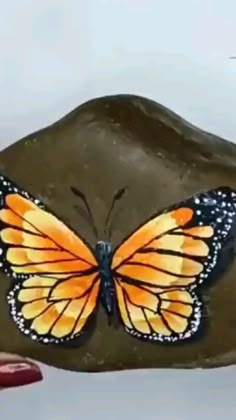 a painting of a butterfly sitting on top of a rock