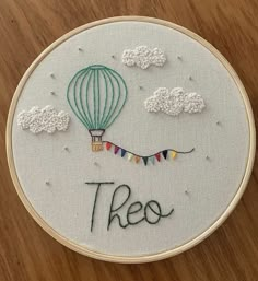 there is a embroidery on the table that says, these are hot air balloons in the sky